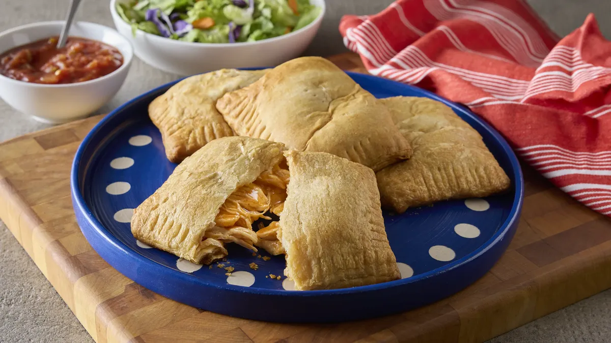Crispy golden crescent rolls that are formed to create a pocket, filled with shredded chicken and coated in an enchilada sauce.