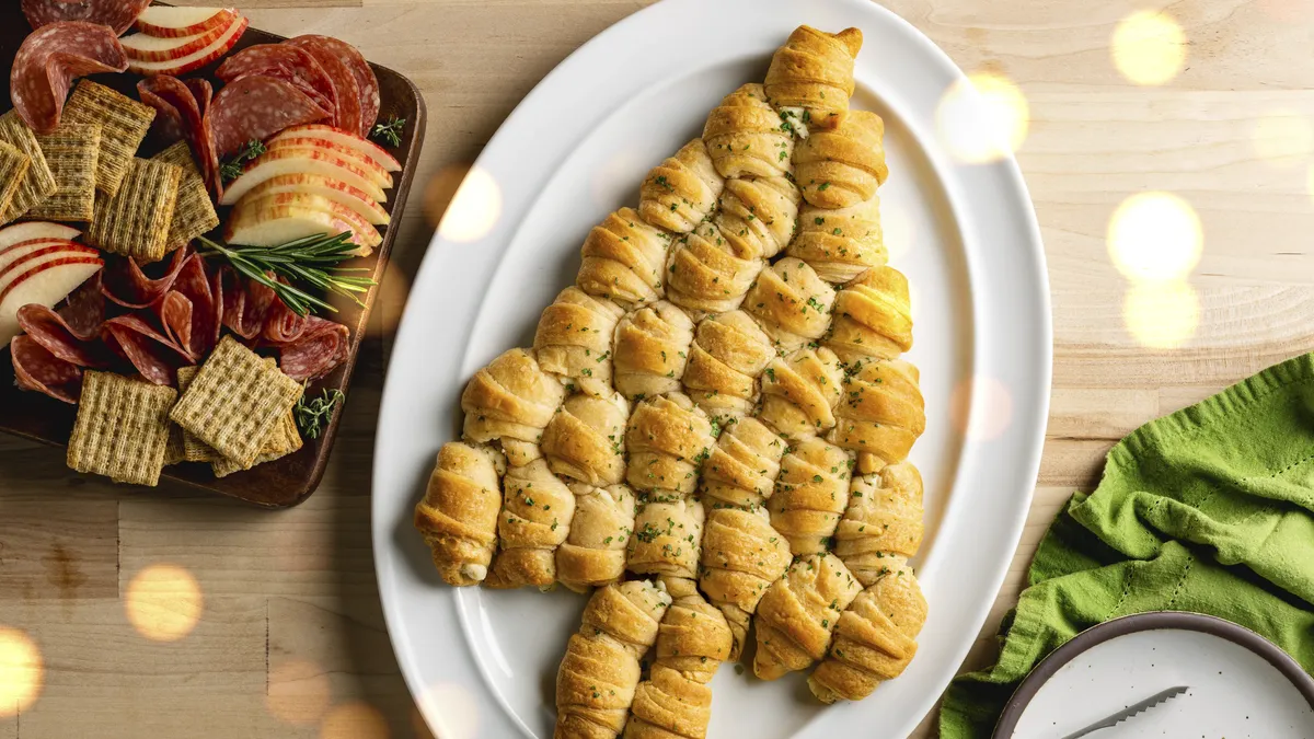 The image displays a Christmas tree pull-apart bread, a festive appetizer made from dough shaped and baked into a tree form.