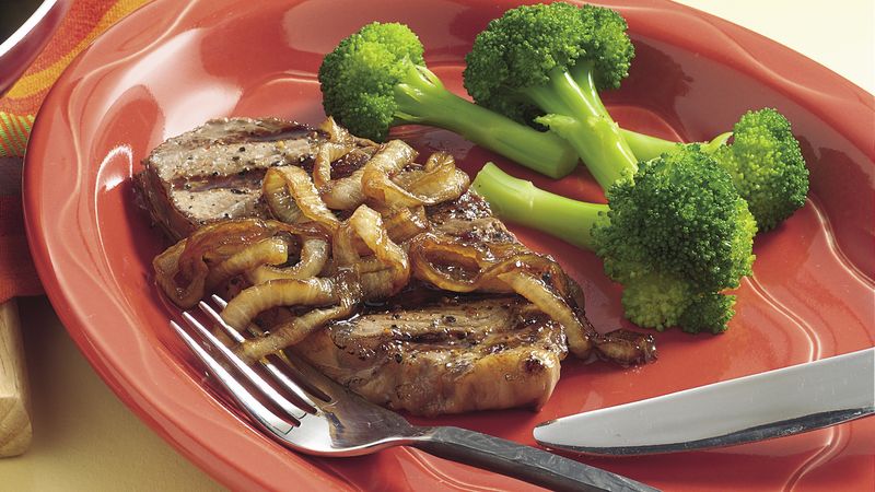 Pepper-Rubbed Grilled Steaks with Caramelized Onions