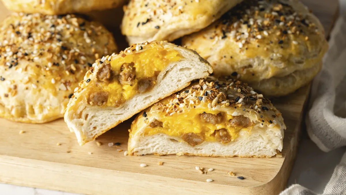 Close-up of golden baked rolls on a wooden board.